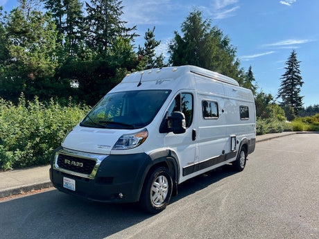 A white Ram rv rental camper van, parked outdoors and ready for your next travel adventure.