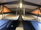 Inside an RV rental: two hanging bunk beds create a compact, adventure-ready sleeping area with inspiring Dr. Seuss decor.