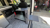 Custom rv rental van interior: kitchen with microwave, sink, and two retractable tables for versatile use.