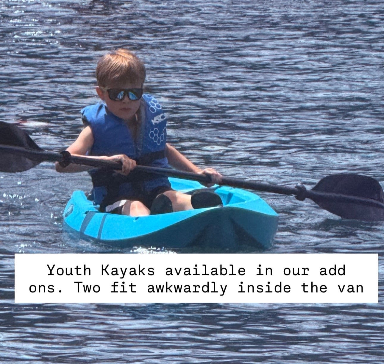 Young boy in blue kayak, life vest & shades. Youth kayaks are great RV rental add-ons for water fun!