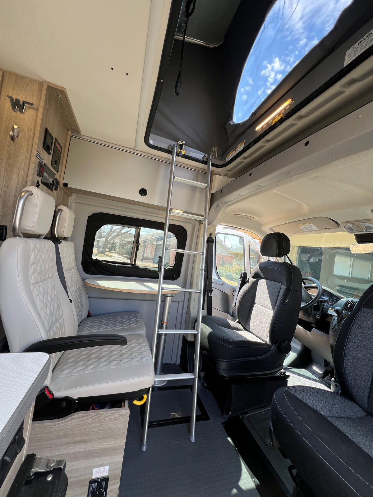 Spacious RV rental interior: features a pop-top bed with ladder access, and comfortable quilted seating. — photo 2