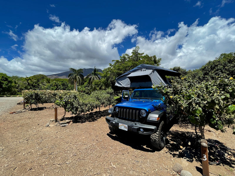 Blue Jeep Wrangler with a rooftop tent, an ideal RV rental for camping adventures in scenic Hawaii, mountains in view. — photo 2