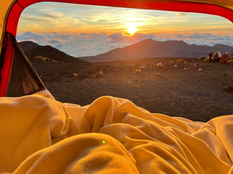 Cozy tent view of a stunning mountain sunrise with fellow campers. Ideal for an RV rental adventure!