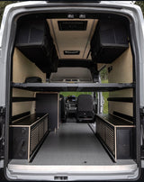Spacious RV rental interior: customized camper van with modular bed, overhead storage, and built-in cabinets.