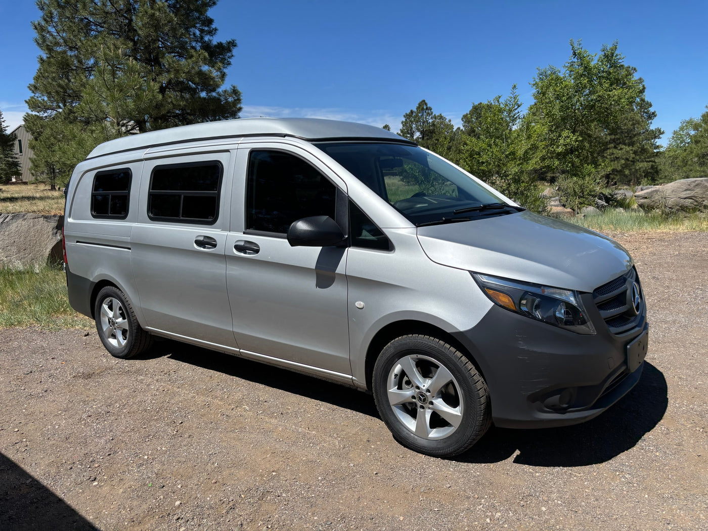 Silver Mercedes RV rental camper van on a dirt road, surrounded by trees under a sunny sky. — photo 12