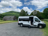 Scenic rv rental stop: white camper van at a farm with a barn, mountains, and hikers.
