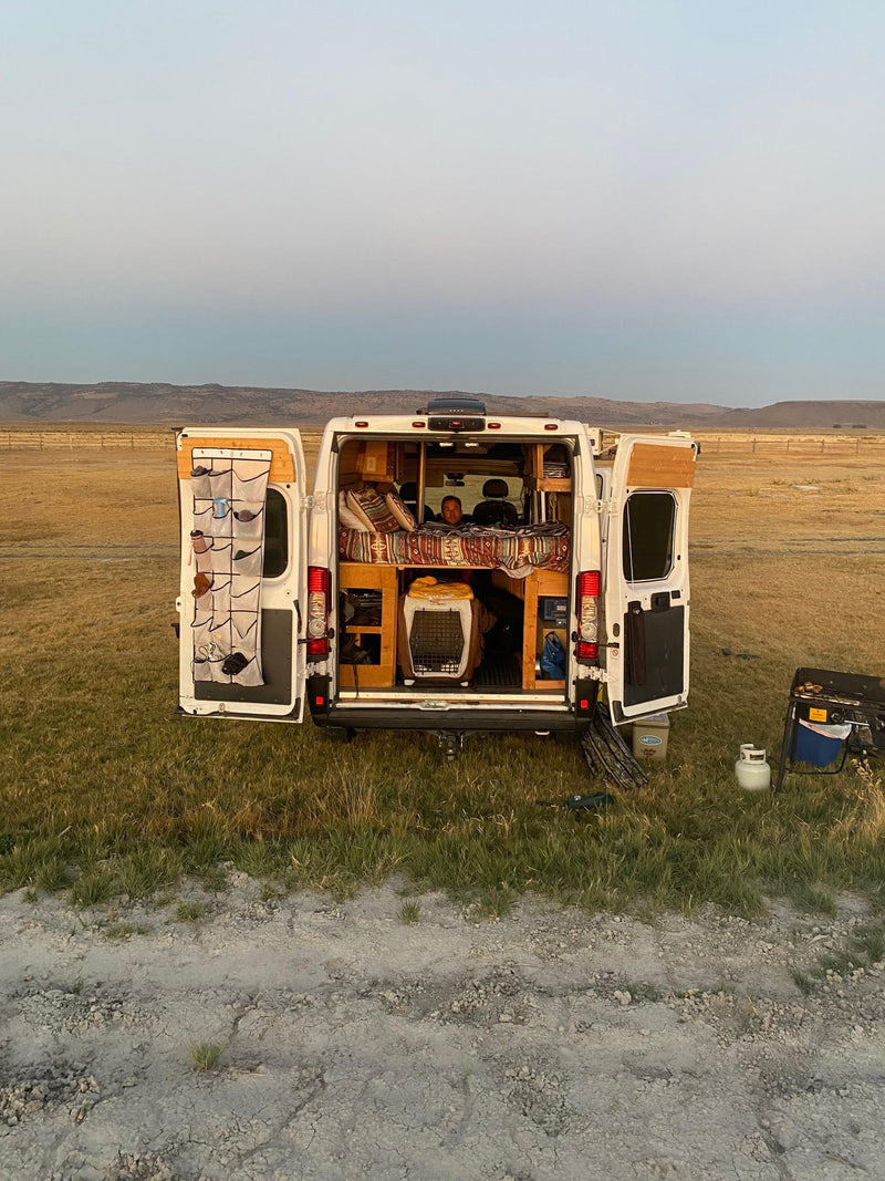  and a person relaxing while watching a projected screen.|Cozy camper van interior featuring a lit wood stove — photo 7