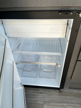 Empty and clean RV rental refrigerator, featuring freezer, wire shelf, and clear storage bins. Ready for your adventure.