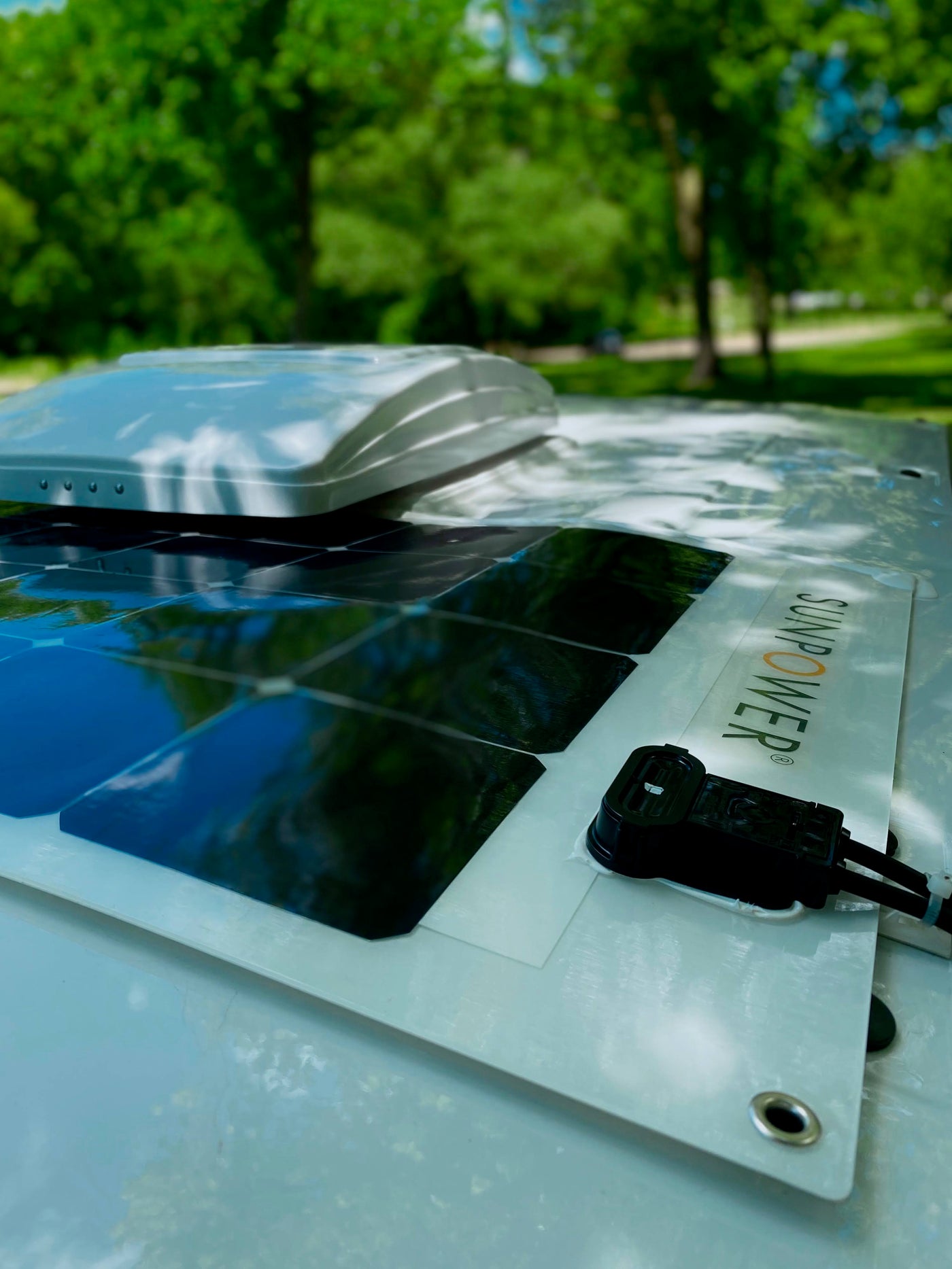 Rooftop view of an RV rental with flexible SunPower solar panels and a vent, powering sustainable adventures. — photo 16