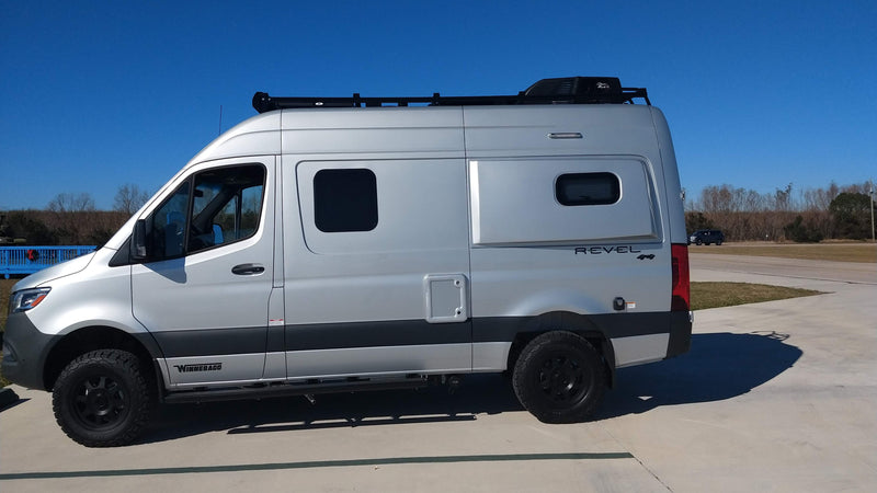 A silver Winnebago Revel 4x4 camper van parked on concrete. Perfect for your next rv rental adventure! — photo 1