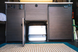Inside this rv rental, a discreet cabinet reveals a portable toilet, flanked by a compact fridge and storage, perfect for campervan adventures.