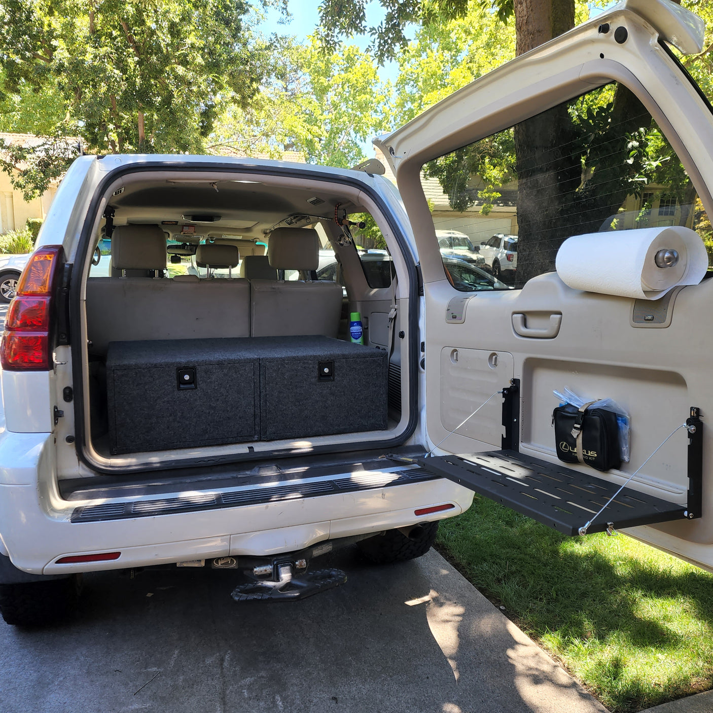 Inside a well-equipped SUV, showing storage boxes & tailgate table for camping. Ideal alternative to an rv rental.