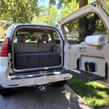 Inside a well-equipped SUV, showing storage boxes & tailgate table for camping. Ideal alternative to an rv rental.