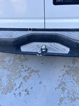 Rear bumper of an RV rental, featuring a step plate and a chrome tow hitch ball. Ready for your next adventure.