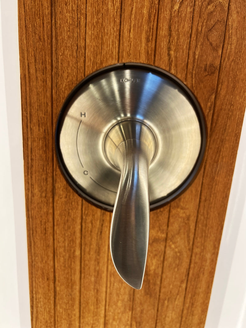 RV rental bathroom: A brushed metal Kohler shower control with 'H' and 'C' settings, set against wood paneling. — photo 17