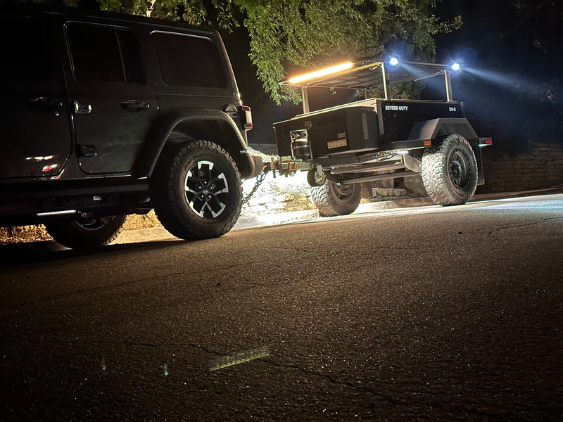 Dark Jeep towing an illuminated Severe-Duty XV-3 overland trailer at night. Great for an outdoor RV rental adventure. — photo 7