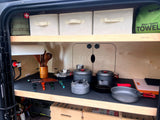 Compact rv rental kitchen: organized cooking gear, power station, and storage in a camper's galley, perfect for adventures.
