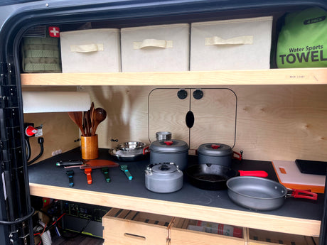 Compact rv rental kitchen: organized cooking gear, power station, and storage in a camper's galley, perfect for adventures.