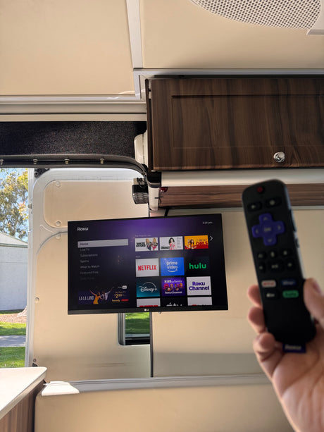 Enjoy entertainment on the go in your RV rental with a Roku TV displaying streaming apps like Netflix, controlled by a remote.