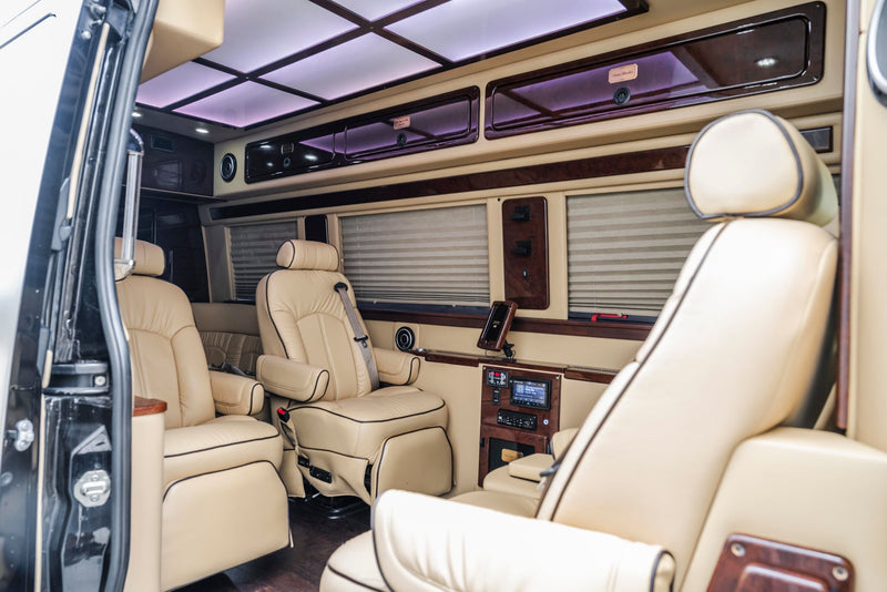  luxury interior with comfortable seating and an illuminated entry step for ease.|Inside a premium RV rental: comfortable cream leather captain's chairs — photo 4