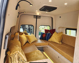 Experience comfort in this custom RV rental interior. Plush mustard cushions and thoughtful lighting create a cozy lounge space.