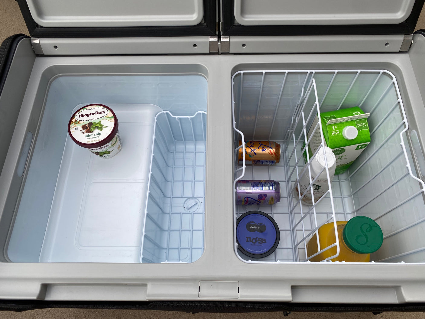 Inside an RV rental cooler: ice cream, milk, juice, yogurt, and drinks, organized for travel.
