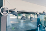 Inside an RV rental: a white peace sign & felt mountain garland adorn the window, adding a touch of travel charm.