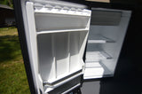 Open, clean, empty refrigerator in an RV rental, with multiple shelves. Ready for your adventure.