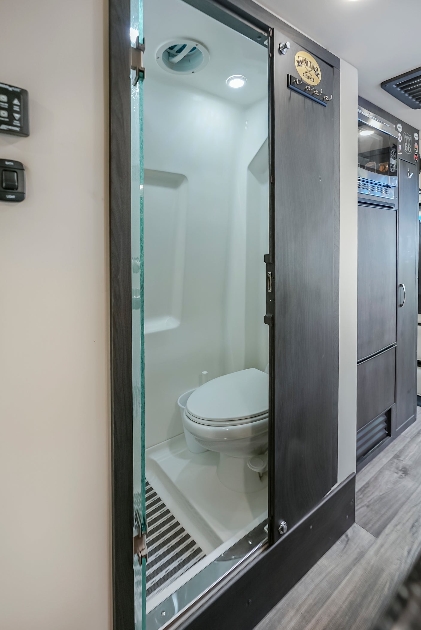 An RV rental's clever compact bathroom design features a toilet, shower, and a space-saving sliding door.