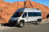 Silver Ram ProMaster camper van RV rental parked against striking red rock landscapes, ready for desert adventures.