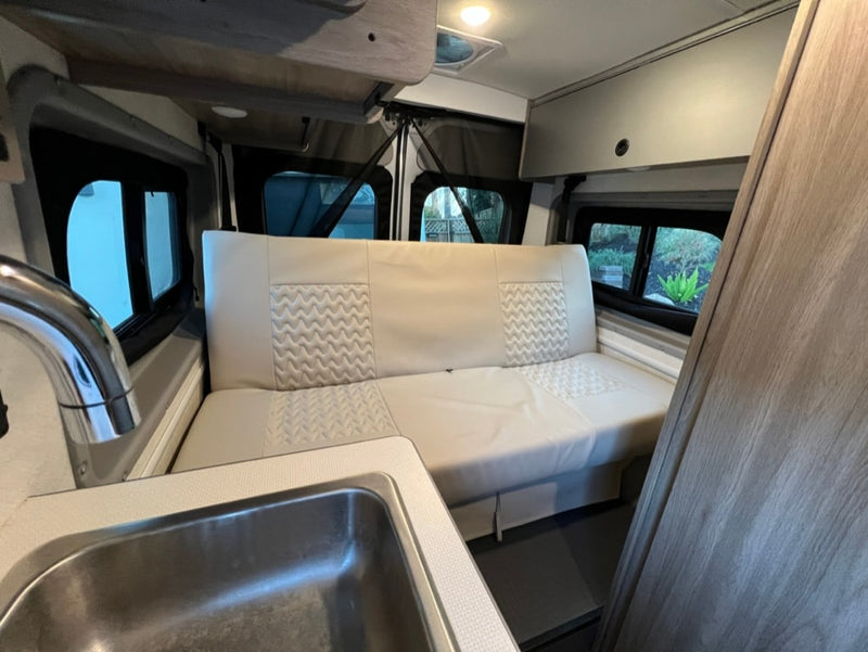 Experience comfort in this RV rental's inviting interior, featuring a clean sink, spacious bench seating, and ample storage. — photo 15