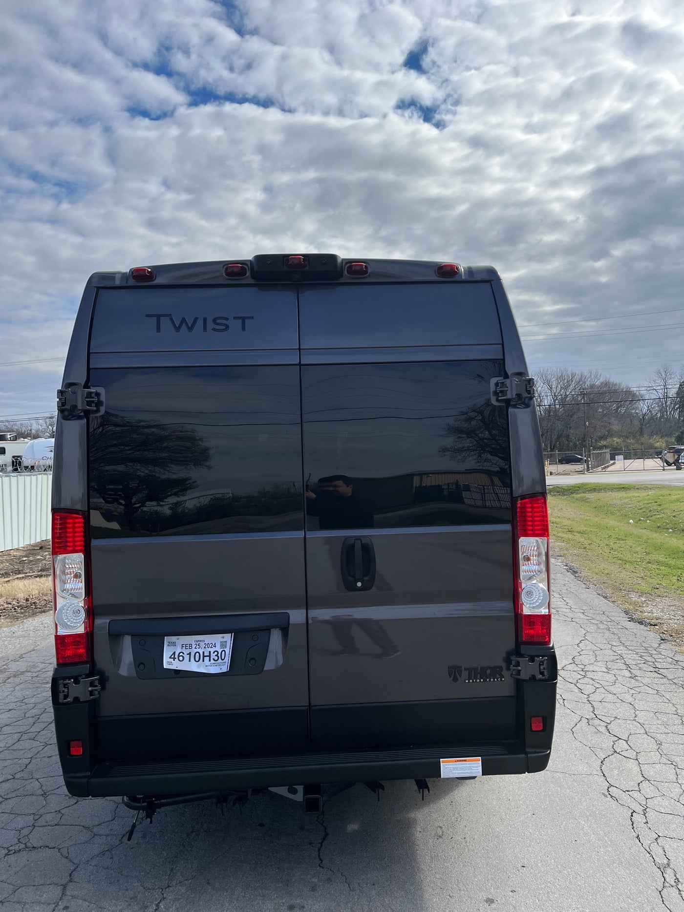 Rear of a dark gray Thor Twist camper van, a great RV rental option. Features a Texas temporary tag. — photo 3
