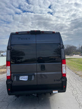 Rear of a dark gray Thor Twist camper van, a great RV rental option. Features a Texas temporary tag.
