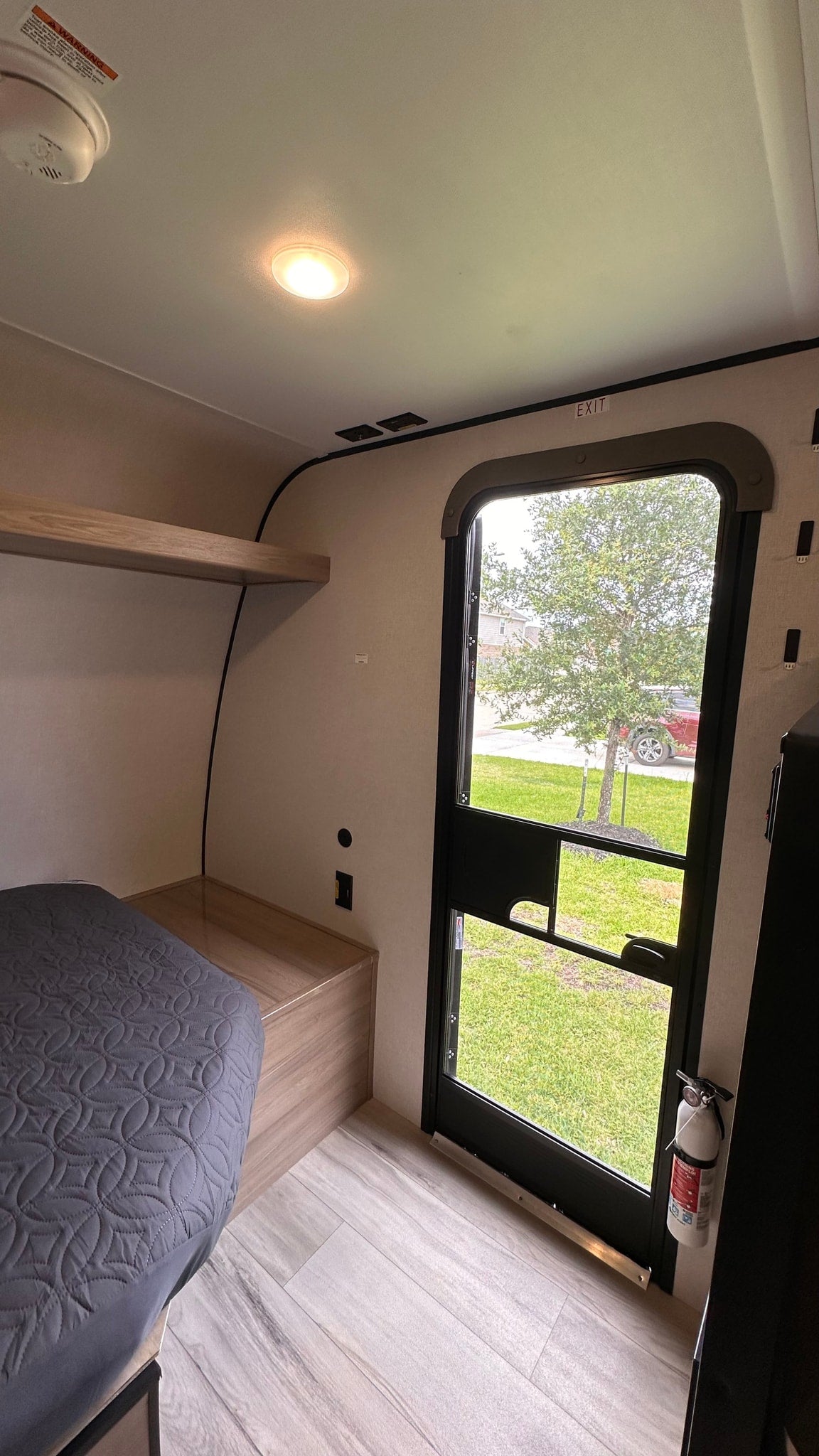  cloudy sky.|New Coleman Terracota4WD travel trailer for rv rental. Sleek white and black camper on concrete under a cloudy sky.|RV rental interior: cozy bed — photo 7