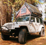 White Jeep Wrangler with a rooftop tent, perfect for an RV rental overlanding adventure.
