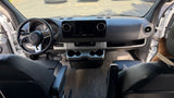 RV rental's front cabin: A modern Mercedes-Benz Sprinter dashboard with steering wheel, infotainment screen, and front seats.