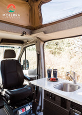  and scenic views outside.|A person cooks outside a grey RV rental campervan