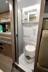 Spacious rv rental interior shows swivel seats, dashboard, and a tranquil lake view for comfortable travel.