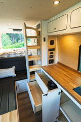 Spacious and modern RV rental interior featuring a bed, ladder, kitchenette, and ample storage, perfect for your next adventure.