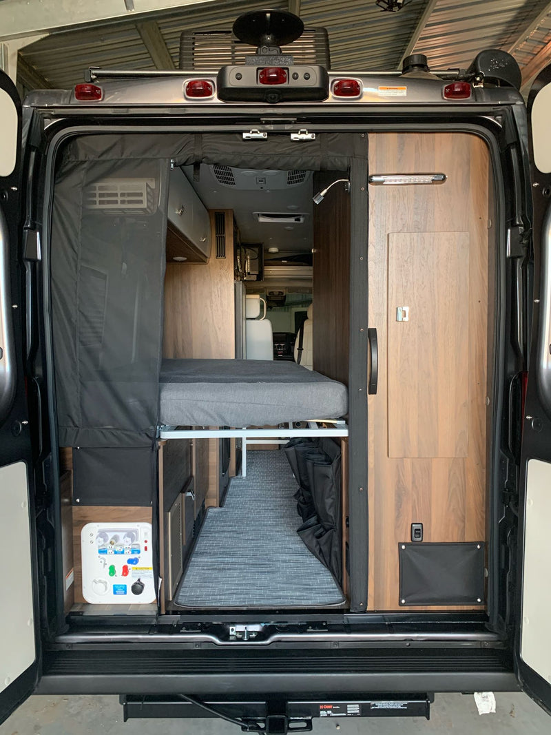  and a compact table.|An RV rental's compact interior: modern kitchen with sink & cooktop — photo 7