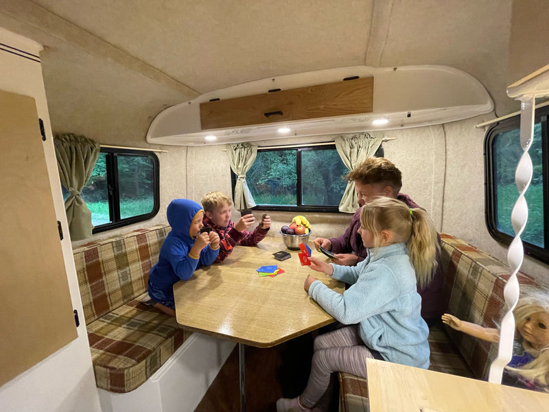  ideal for camping trips.|Small Scamp RV rental set up at a wooded campsite with an awning — photo 10
