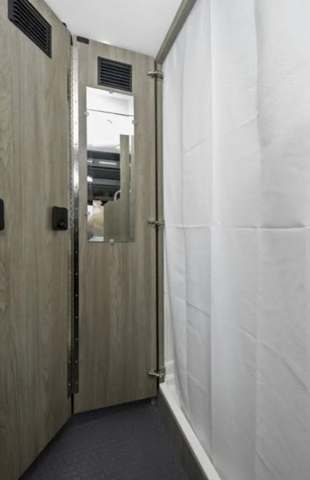  and the driver's cockpit beyond.|RV rental interior showing a compact bathroom with toilet