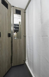  and the driver's cockpit beyond.|RV rental interior showing a compact bathroom with toilet