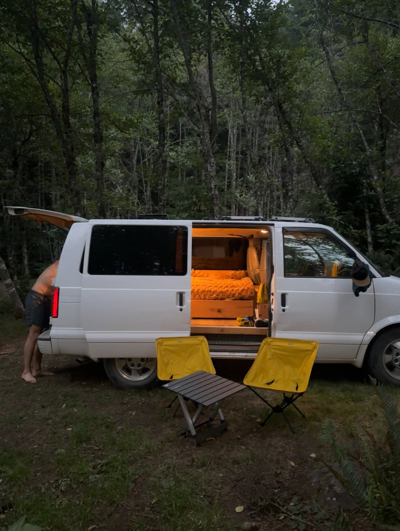 Forest camping with a cozy RV rental van. Its interior is lit — photo 1