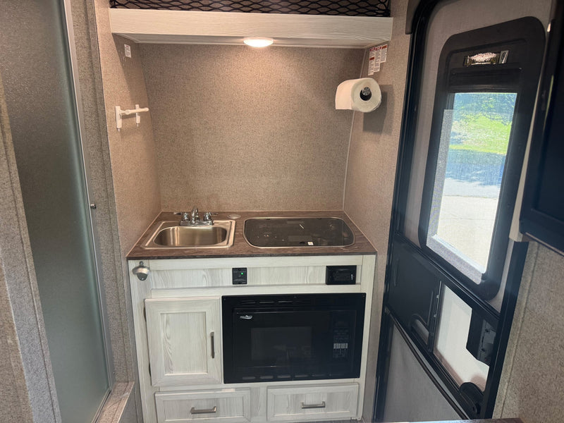  parked on gravel for your next camping adventure.|A sleek white and green Flagstaff E-Pro travel trailer sits on gravel — photo 7