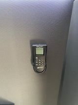 MaxxAir remote control on textured surface, essential for RV rental climate management, with buttons for fan, temp, modes.