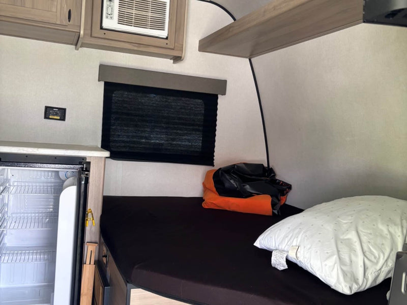  and light stone-look countertops.|RV rental bunk beds: A cozy interior shot of two bunks with black mattresses — photo 12