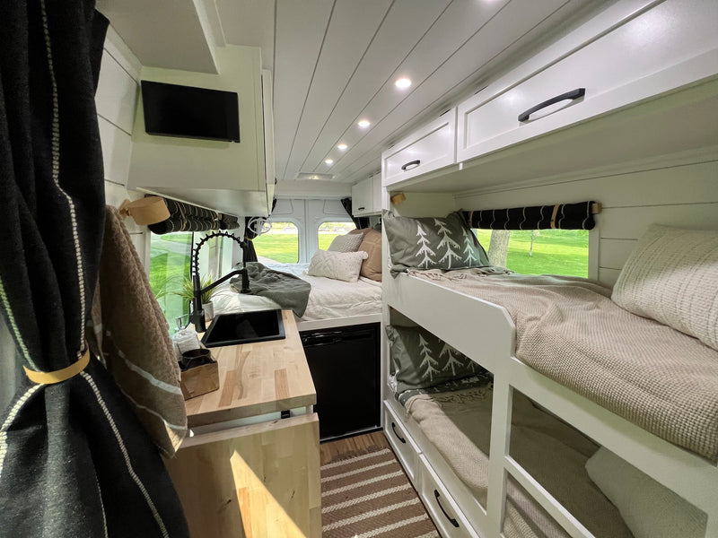 Bright RV rental interior: kitchen with sink, main bed, and bunk beds for family comfort. — photo 9