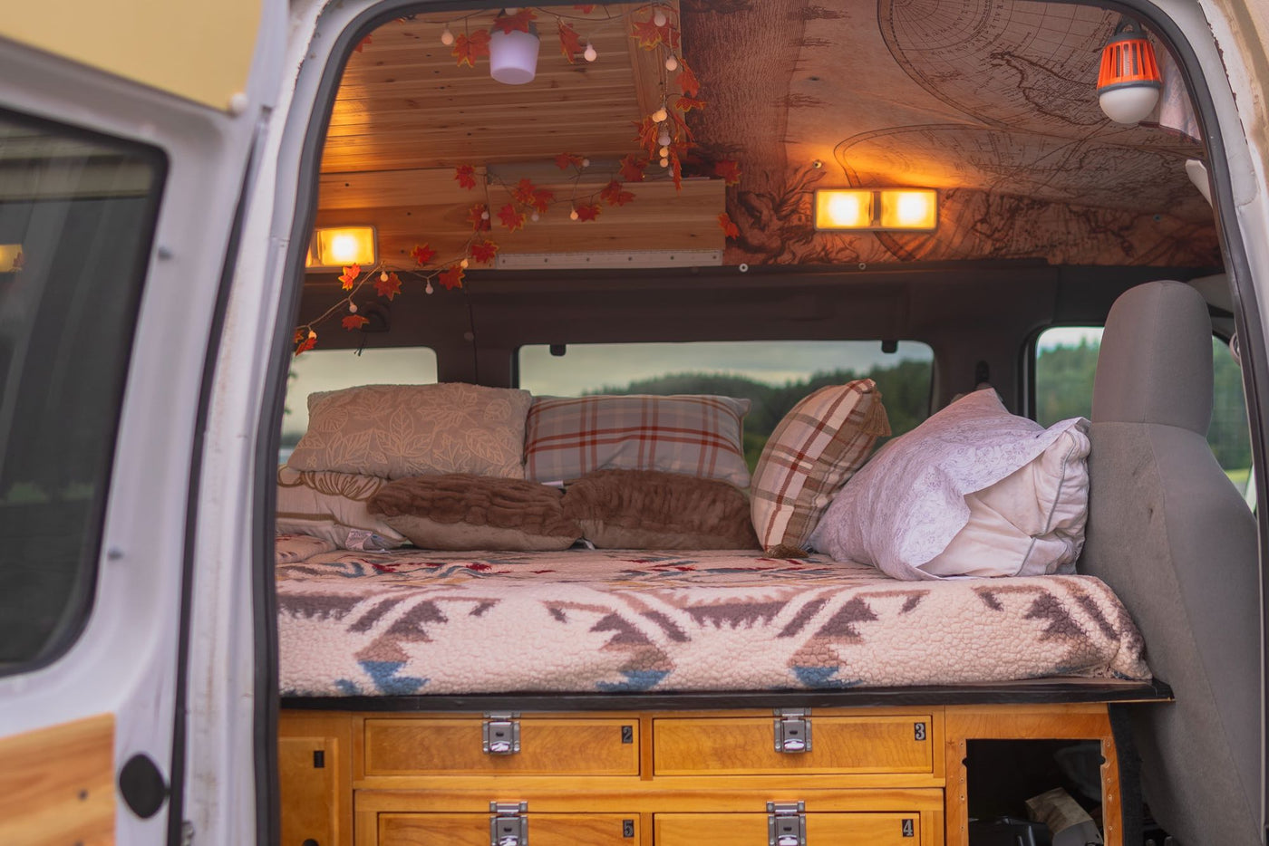 viewed through open rear doors.|Cozy RV rental interior with a wooden bench — photo 18