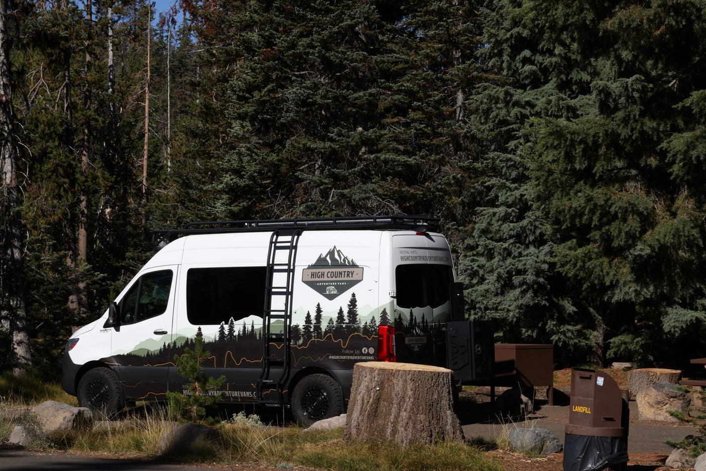 High Country RV rental camper van at a forest campsite. Ready for outdoor adventure and nature exploration.